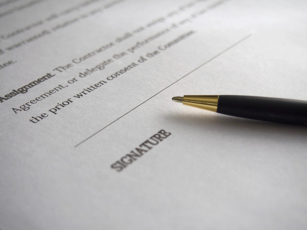 Firmare un documento che rappresenta l'importanza di un accordo di incarico scritto prima di pagare per l'assistenza in materia di immigrazione.